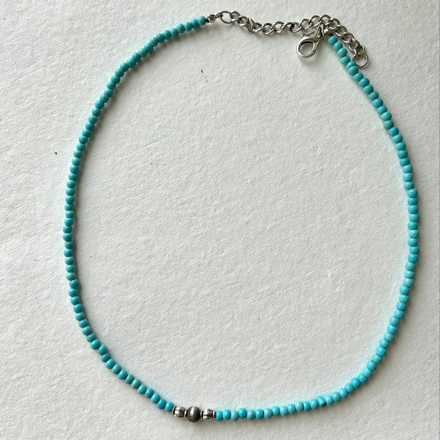 Turquoise beaded necklace on a white background