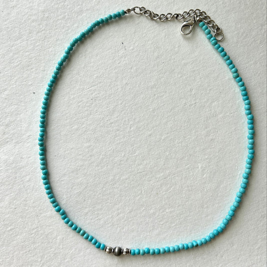 Turquoise beaded necklace on a white background